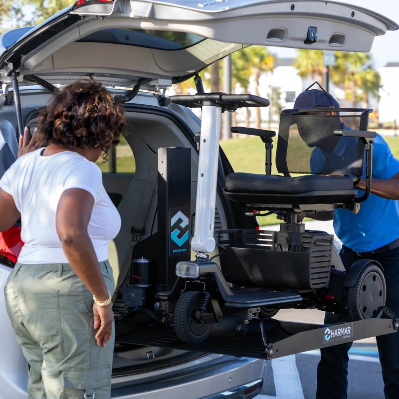 The AL600 raising a power chair into the back of a white SUV