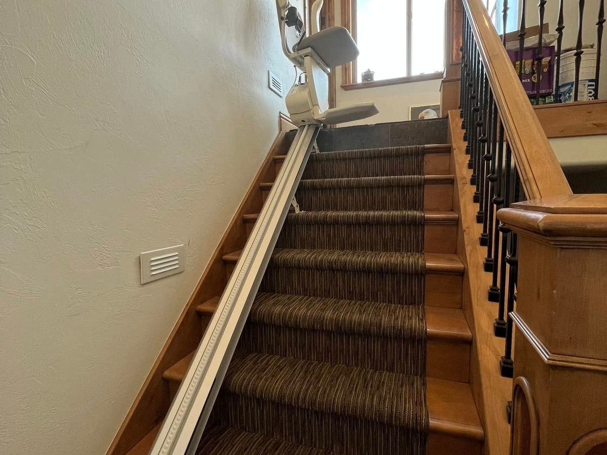 Lazo install: rail up a long runner staircase to the lift folded at the top