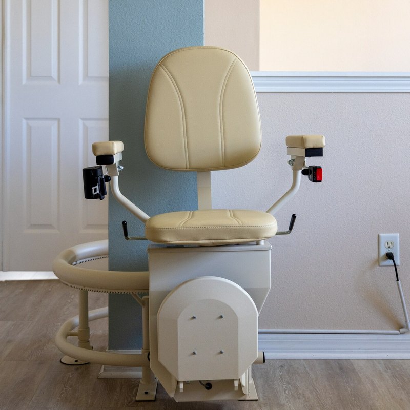 Harmar Helix curved stair lift parked at the bottom of the stairs, its curved rail curling round onto the floor