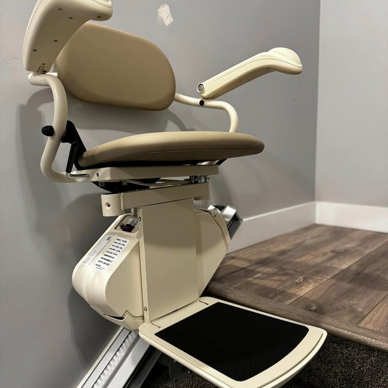 Harmar SL300 stair lift parked at the top of a carpeted staircase