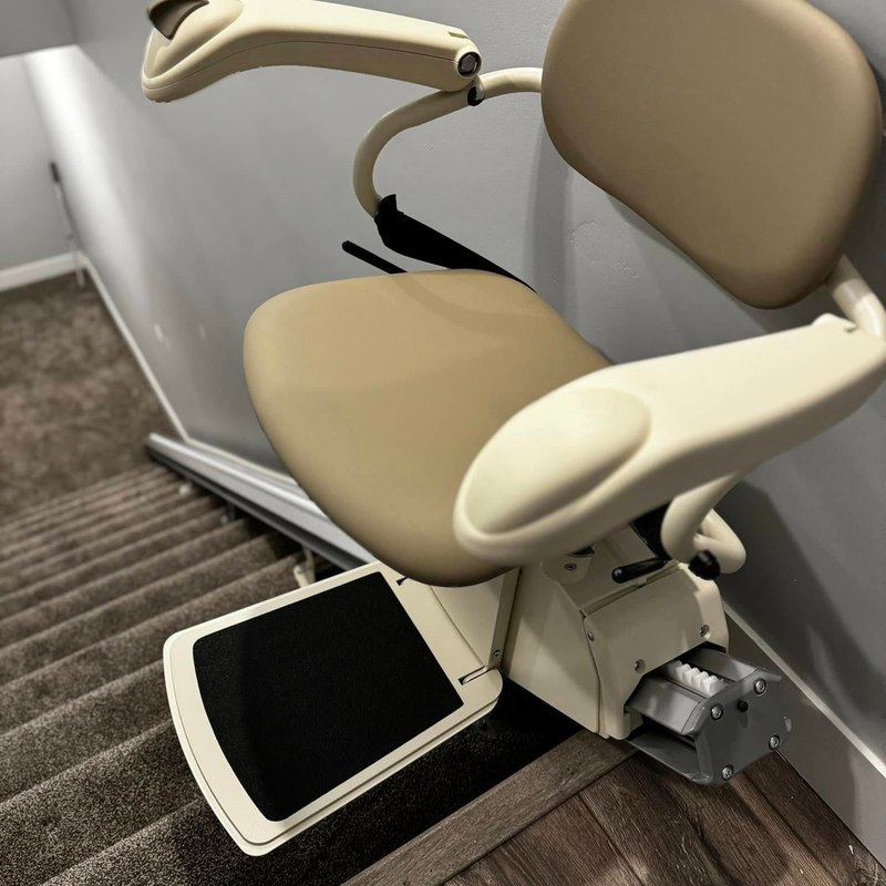 Harmar SL300 stair lift ready at the bottom of a carpeted staircase